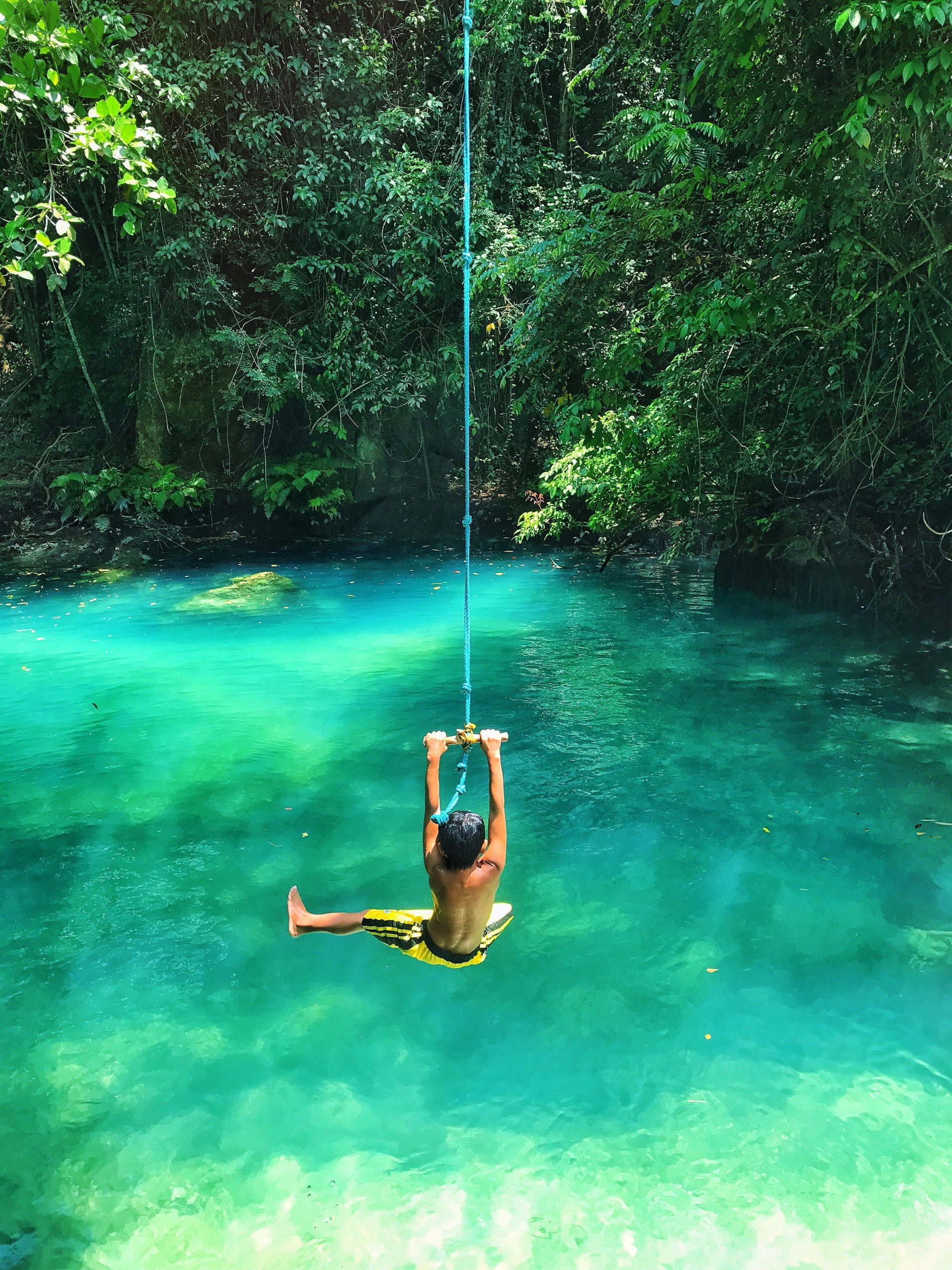 photo-of-boy-swinging-over-body-of-water-2413238-scaled